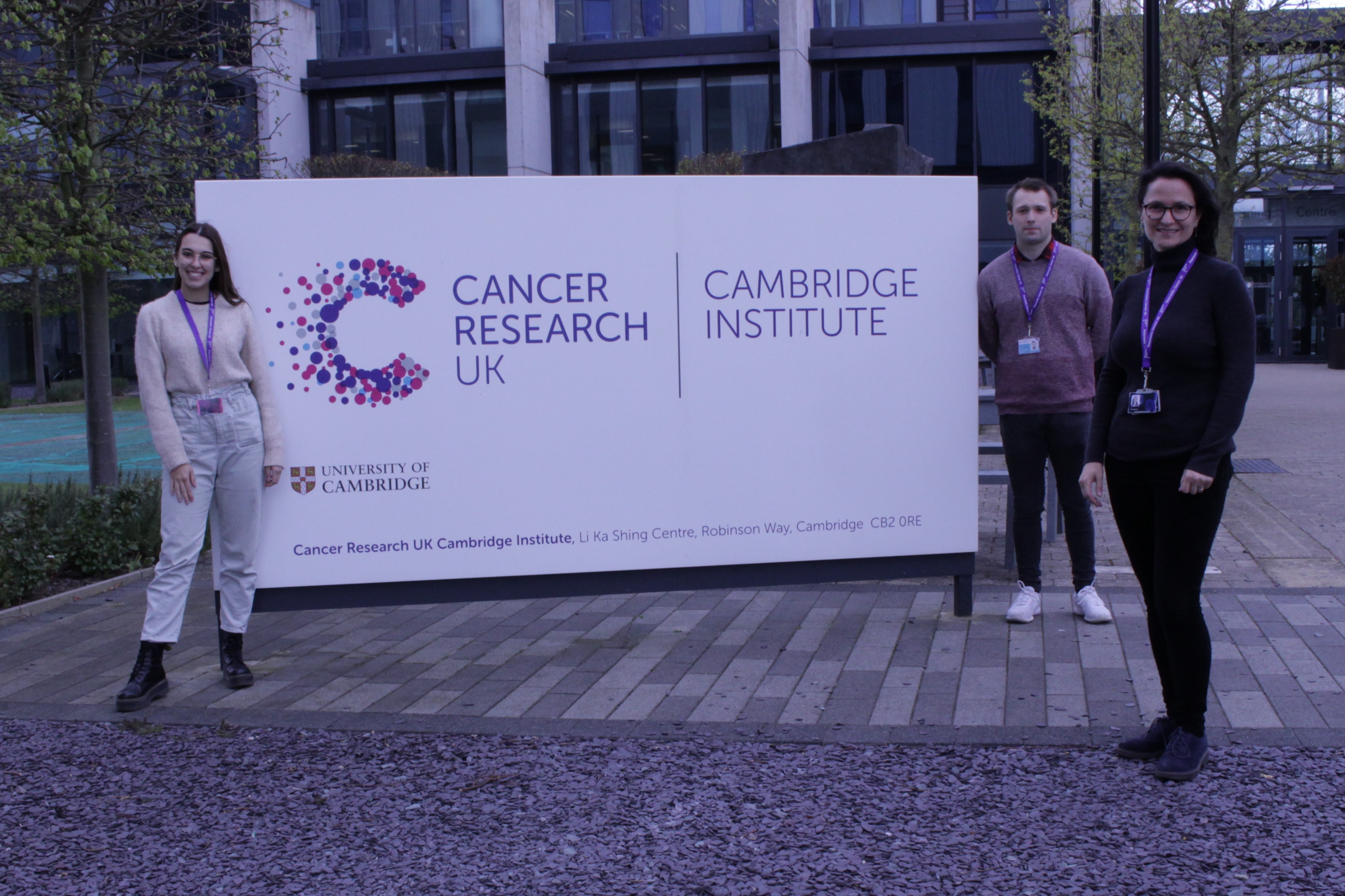Three students outside the CRUK Cambridge Institute